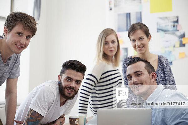 Group of creative professionals with laptop at table
