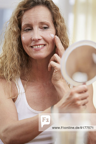 Porträt einer Frau mit Gesichtscreme
