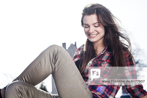 Porträt einer lächelnden jungen Frau auf dem Autodach