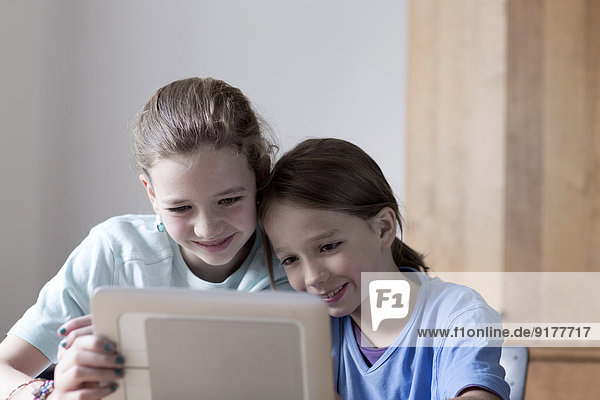 Bruder und Schwester beim Betrachten des Tablet-Computers zu Hause