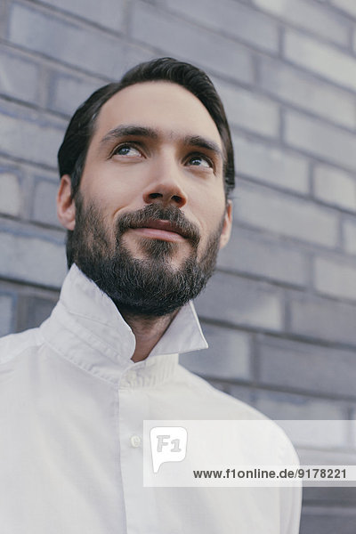 Portrait of young bearded man wearing white shirt