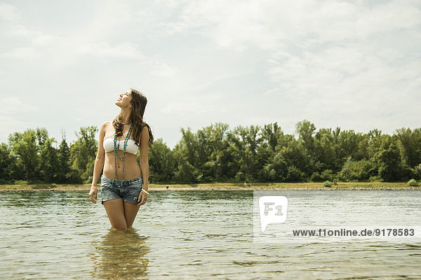 Young woman relaxing at waterside of Rhine river