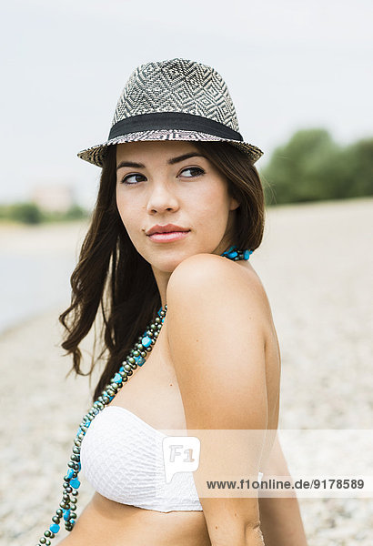 Portrait of young woman wearing hat on the beach