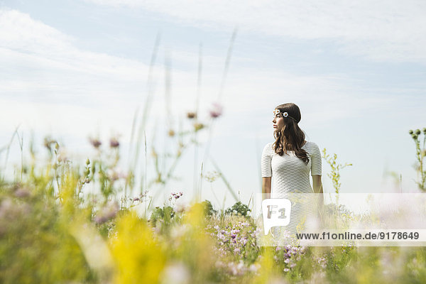 Junge Frau auf Blumenwiese stehend
