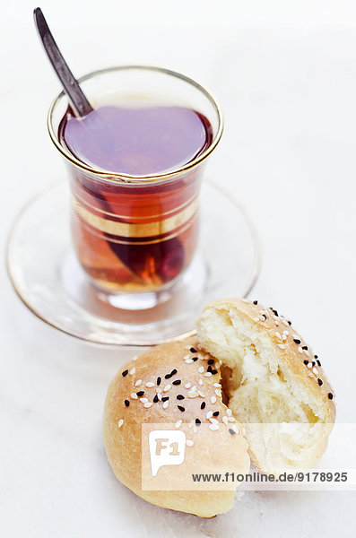 Glas schwarzer Tee und hausgemachtes türkisches Hefebrot gefüllt mit Schafskäse