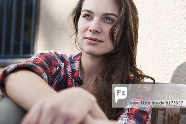Relaxed young woman sitting outdoors