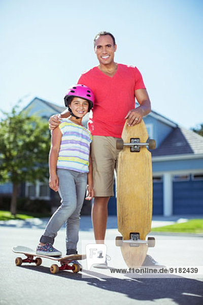 Vater und Tochter mit Skateboards