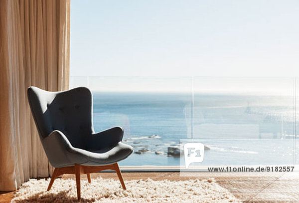 Stuhl im sonnigen Fenster mit Blick aufs Meer