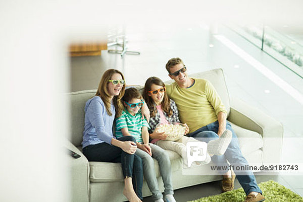Familie beim 3D-Fernsehen im Wohnzimmer