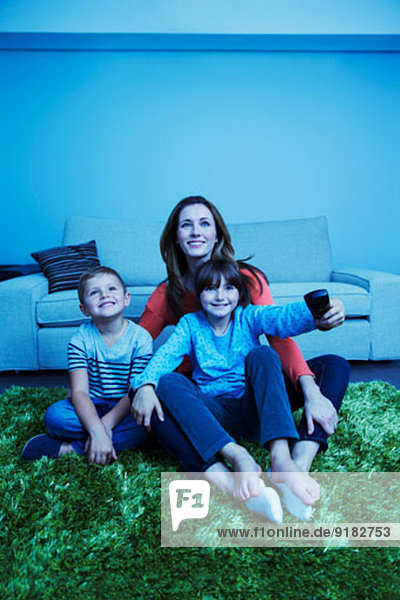 Mutter und Kinder beim Fernsehen im Wohnzimmer