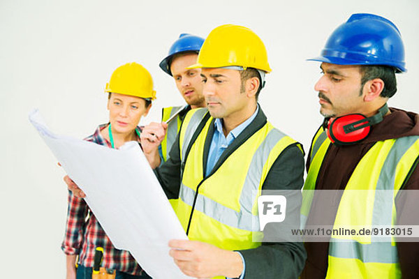 Bauarbeiter beim Betrachten von Bauplänen