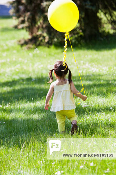 Mädchen mit Ballon im Garten
