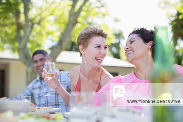 Women talking at table outdoors