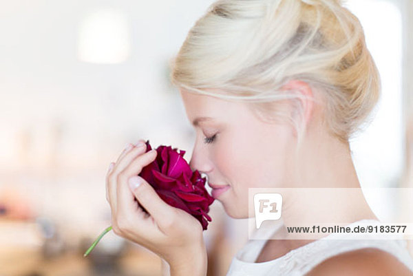 Frau riecht Rose