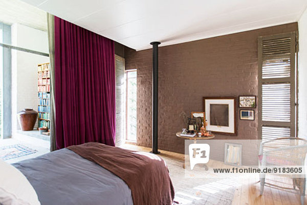 Bett  Beistelltisch und Bilder im rustikalen Schlafzimmer