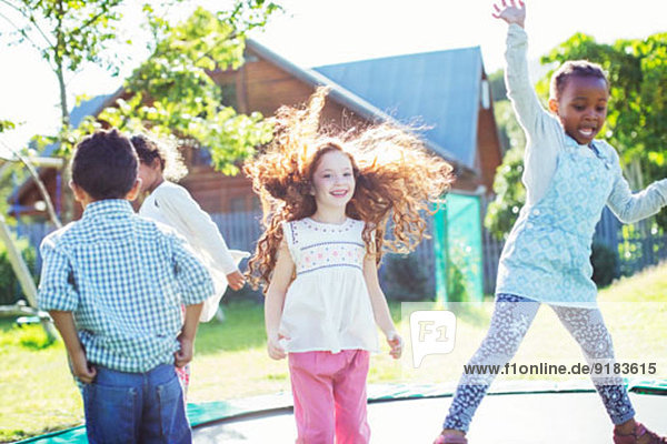 Children jumping on trampoline outdoors