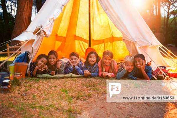 Kinder lächeln im Tipi auf dem Campingplatz