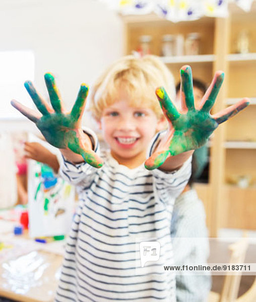 Schüler zeigt schmutzige Hände im Klassenzimmer