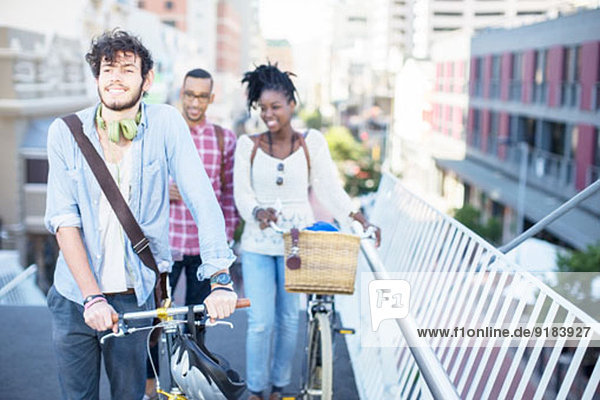 Freunde schieben Fahrräder auf der Stadtstraße