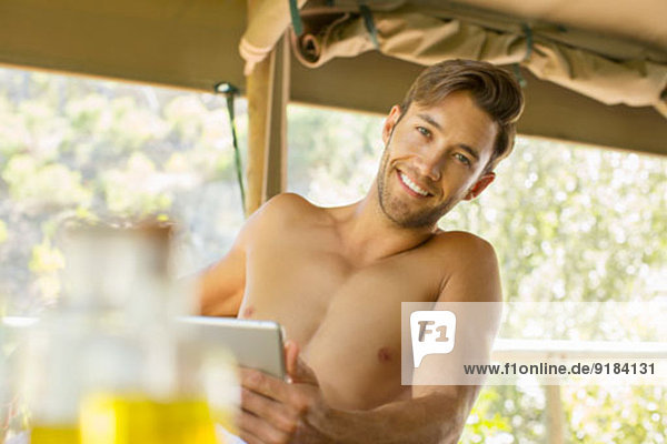 Mann mit digitalem Tablett auf dem Balkon