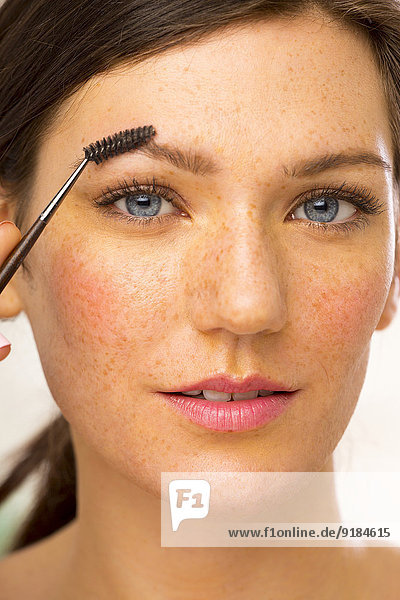 Caucasian woman applying makeup