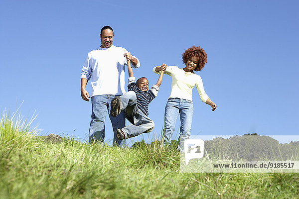 African American family walking together in field