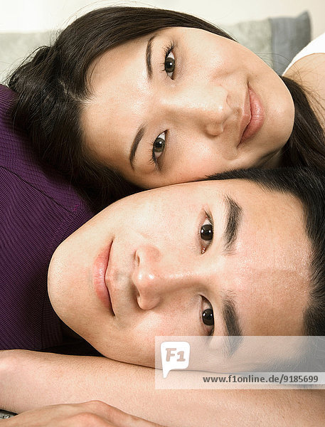 Chinese couple relaxing on bed