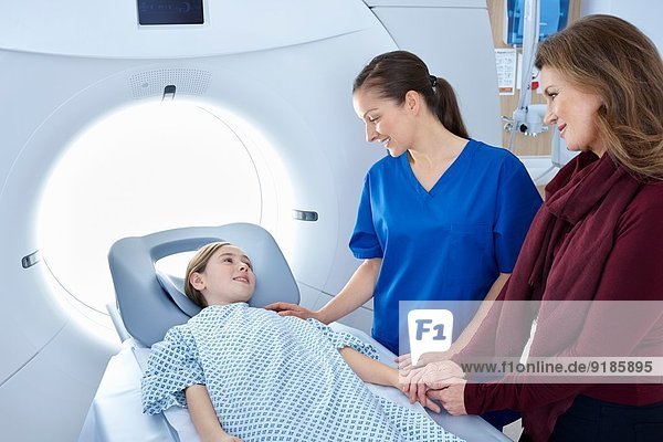 Röntgen-Assistentin und Mutter Beruhigendes Mädchen gehen in den CT-Scanner