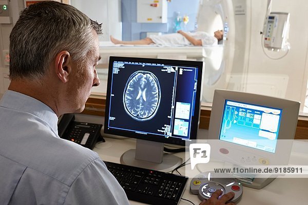 Radiologist looking at brain scan image on computer screen