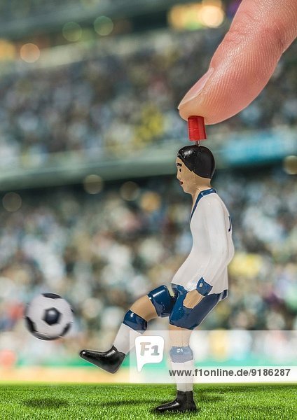 Digital erzeugtes Bild eines Fußballspielers  der den Ball im Stadion kickt.
