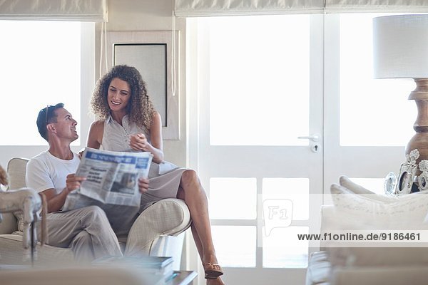 Paar liest Zeitung im Wohnzimmer