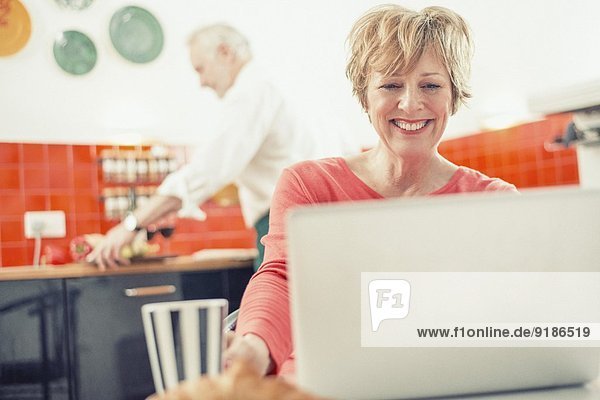 Mature woman using laptop in kitchen