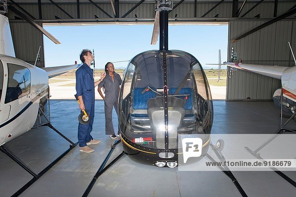 Flugschüler überprüfen das Äußere des Hubschraubers