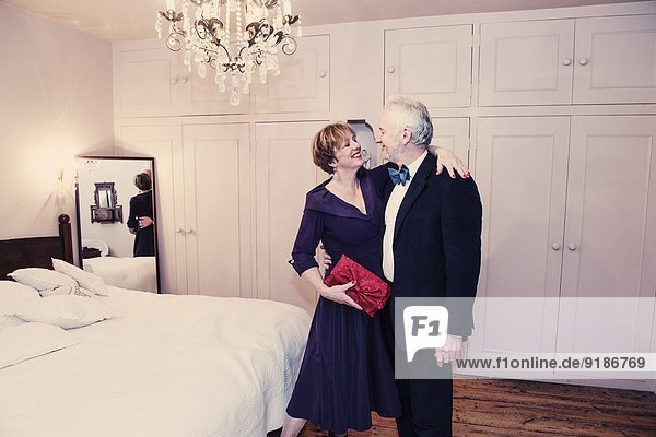 Paar im Schlafzimmer  reife Frau mit Arm um den älteren Mann