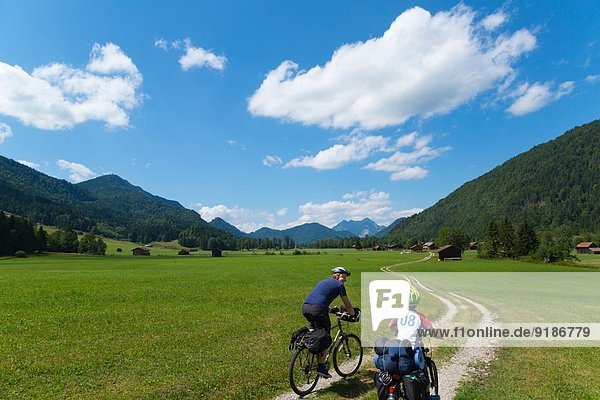 Father and son cycling through Jachenau  Bavaria  Germany