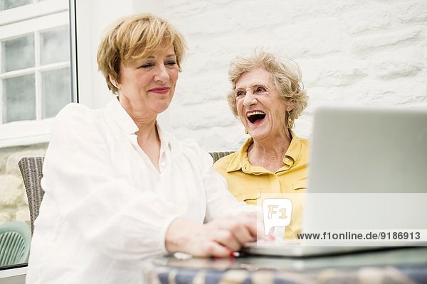 Senior woman and daughter  using laptop