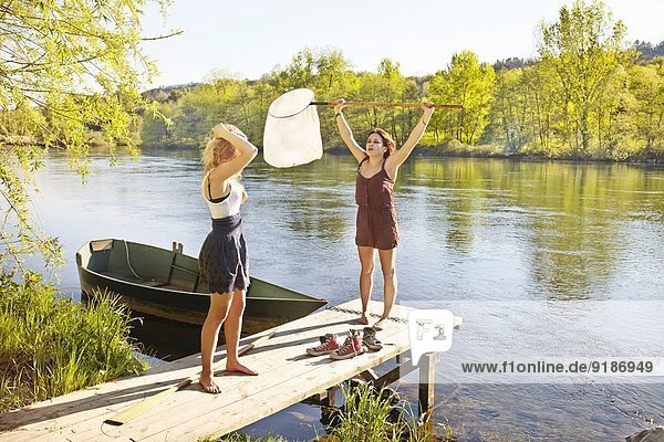 Junge Frauen am Steg  eine mit Fischernetz