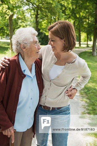 Senior woman and granddaughter standing in park