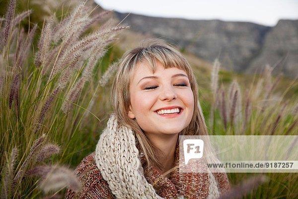 Bildnis einer jungen Frau im langen Gras mit geschlossenen Augen
