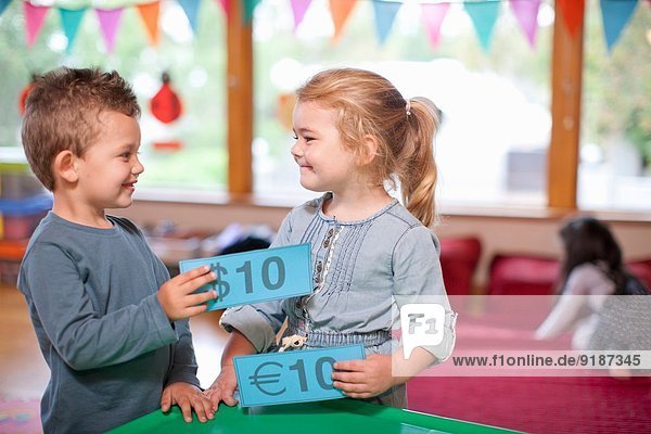 Junge und Mädchen zählen Euro-Währung im Kindergarten