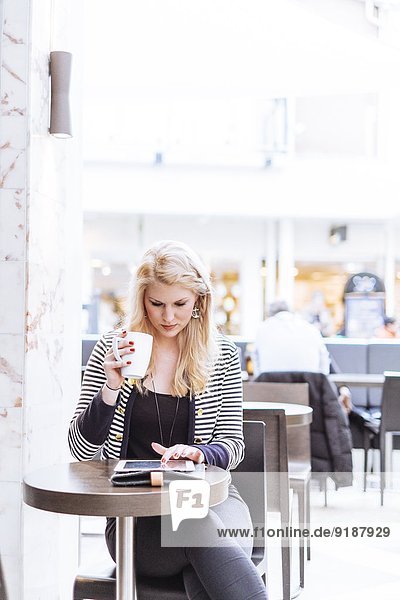 Young woman in cafe using digital tablet