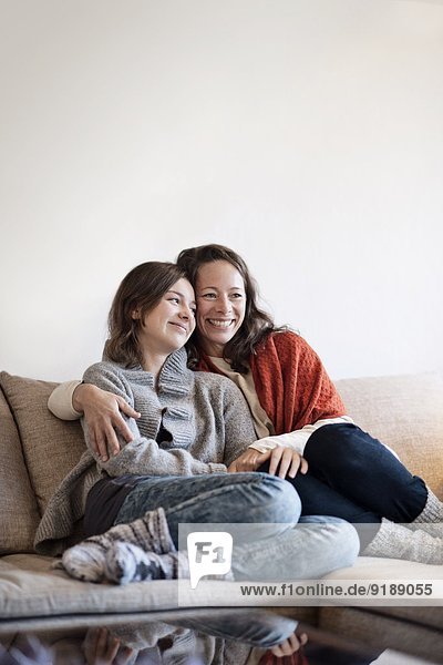 Mother and teenage daughter on sofa