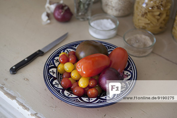 Various tomatoes with onion in plate