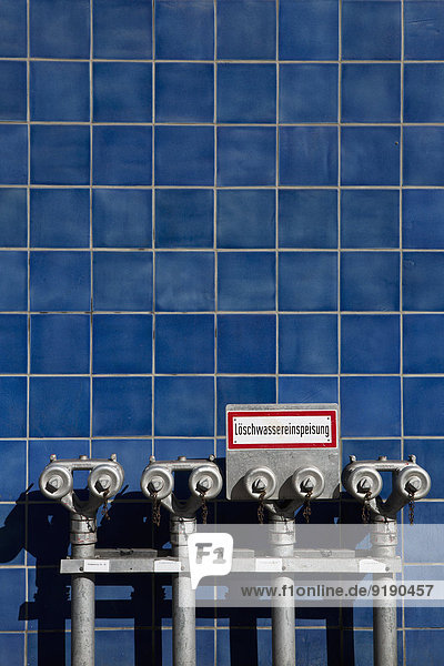 Hydranten gegen blaue Fliesenwand