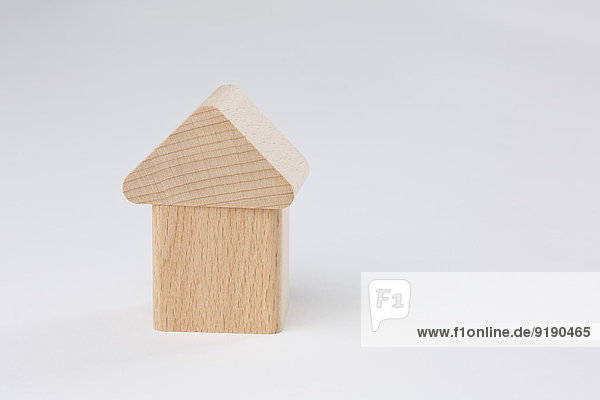 Holzhaus-Miniatur vor weißem Hintergrund