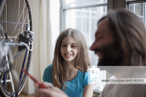 Vater und Tochter reparieren Fahrrad zu Hause