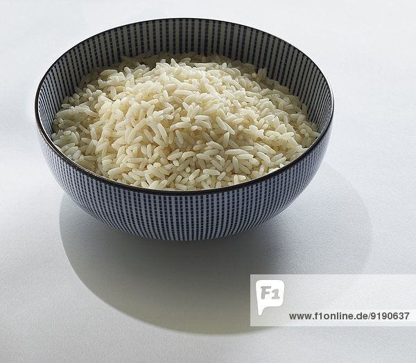 Klebriger Reis in der Schale über grauem Hintergrund
