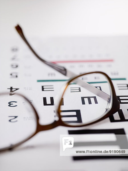 Nahaufnahme des Alphabets E auf der Augenuntersuchungstabelle durch die Brille gesehen