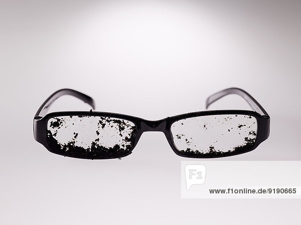 Schmutzige Brille über grauem Hintergrund