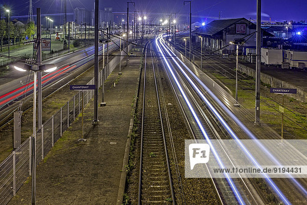 Lange Exposition von Zügen  die nachts auf der Eisenbahn fahren  Gare de Chantenay  Nantes  Loire-Atlantique  Frankreich